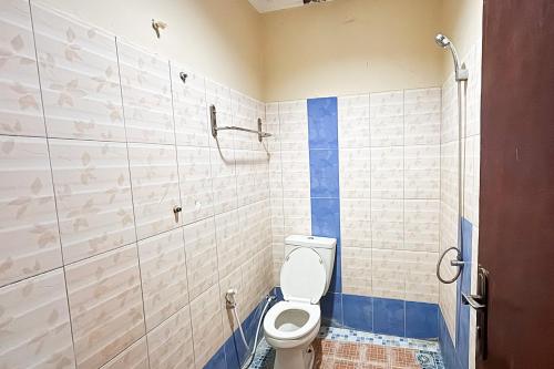 a bathroom with a toilet and a shower at Hotel Entrop Jayapura RedPartner in Pim