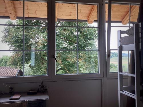 two windows in a room with a view of a tree at Bi&Babette in Cocconato