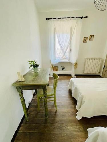 a bedroom with a table and a bed and a window at La casa di Regina in Tronzano Vercellese