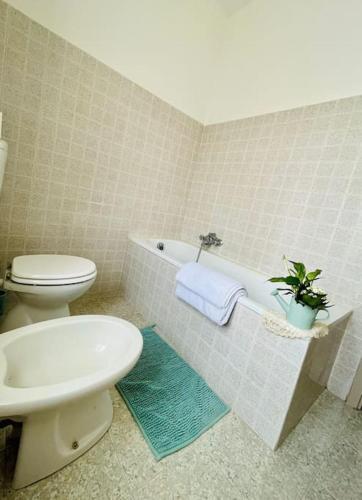 a bathroom with a toilet and a sink and a tub at La casa di Regina in Tronzano Vercellese