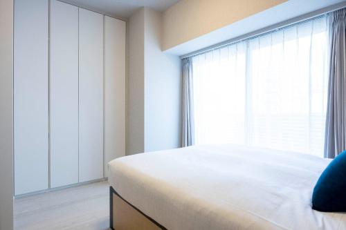 a bedroom with a bed and a large window at MAT Ryogoku in Tokyo