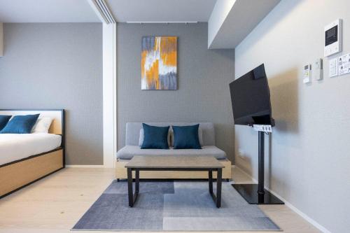 a bedroom with a bed and a tv and a couch at MAT Ryogoku in Tokyo