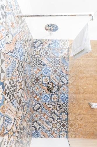 a bathroom with a mosaic tile floor and a shower at B&B Gusto West in Bisignano