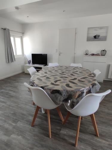 une table et des chaises dans une pièce blanche dans l'établissement Escapade Normande, à Goderville