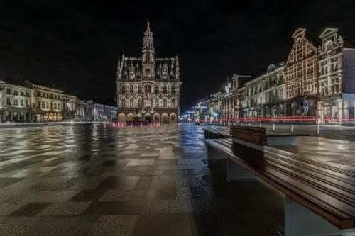 a city street at night with a large building at Leopold Hotel Oudenaarde in Oudenaarde