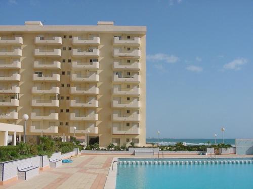 a large building with a swimming pool in front of it at Apartamentos Ágata V.v. in La Manga del Mar Menor