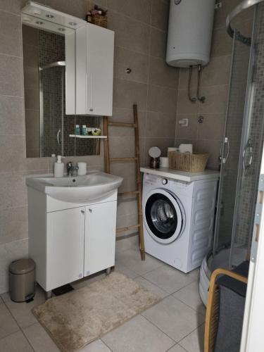a bathroom with a washing machine and a sink at Sunset in Teslić