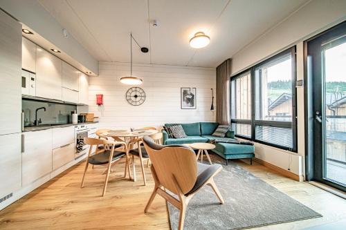 una cucina e un soggiorno con tavolo e sedie di Ski Chalet C10 by Aavalevi Holidays, Levi Center incl 2 ski passes a Levi