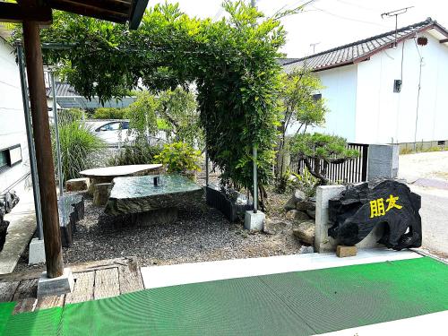 a garden with a bench and a picnic table at 一棟貸しの朋友 in Zentsuji