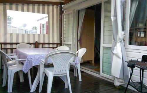 una mesa y sillas en el porche de una casa en Beautiful Stacaravan, en Saint-Jean-de-Monts