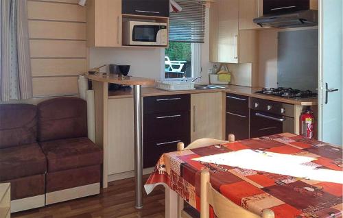 Una pequeña cocina con una mesa y un sofá. en Beautiful Stacaravan, en Saint-Jean-de-Monts