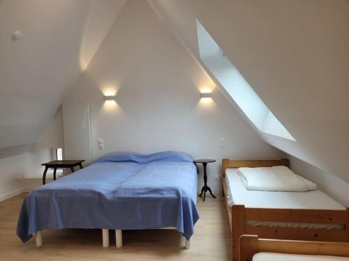 una camera da letto con letto e panca in mansarda di Le clos du prieuré - Les Gîtes de la Côte d'Amour a Batz-sur-Mer