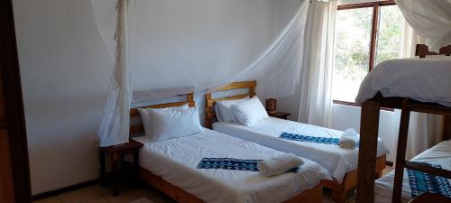 two twin beds in a room with a window at Bay View Lodge in Miramar
