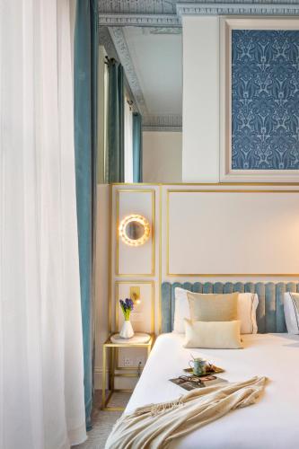 a bedroom with a bed with a blue wall at Meliá London Kensington Member of Meliá Collection in London