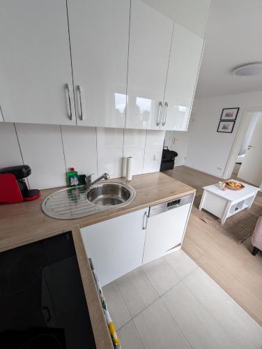a kitchen with white cabinets and a sink at 2 Zimmer Apartment mit Balkon in Eislingen