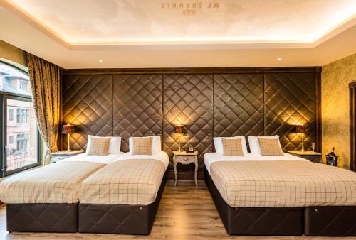 two beds in a hotel room with a headboard at The Shankly Hotel in Liverpool