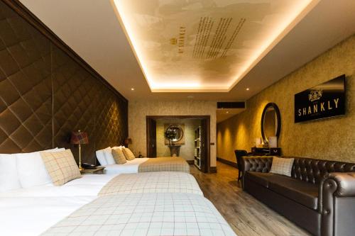 a hotel room with two beds and a couch at The Shankly Hotel in Liverpool