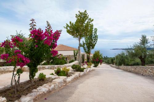 a road leading to a house with pink flowers at Camvillia Resort Messinia in Vounaria