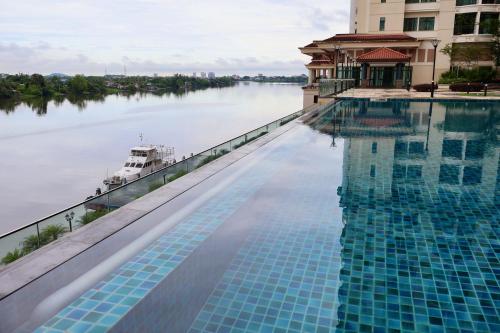 a swimming pool with a view of the river at KuchingCity - Snuggle - Sunset City View w Balcony in Kuching
