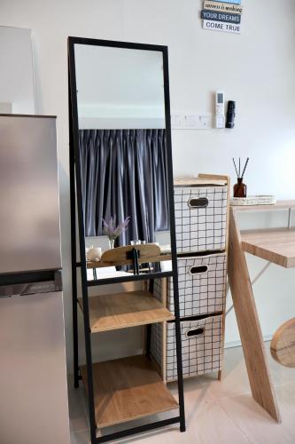 a mirror on a stand next to a dresser at KuchingCity - Snuggle - Sunset City View w Balcony in Kuching