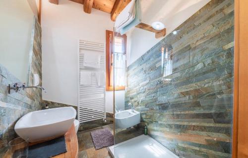 a bathroom with a toilet and a stone wall at Agriturismo Dolce Colle in Volpago del Montello