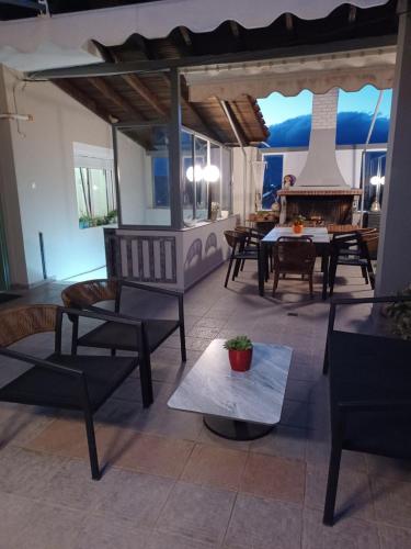 a living room with chairs and a table and a fireplace at Marvic House in Exaplátanos