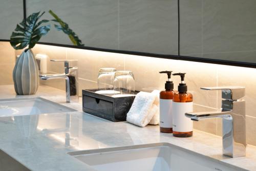 a bathroom counter with two sinks and a mirror at GM Estate Hotel and Executive Apartments Sukhumvit 20 in Bangkok