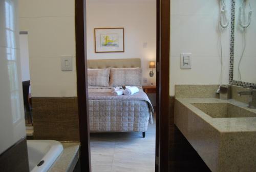 a bathroom with a bed and a tub and a sink at Pousada Bahia Pelô in Salvador