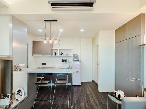 a kitchen with a counter and chairs in a room at 運河十六 海港景觀整層主臥房Canal16 HarborView Studio in Tainan