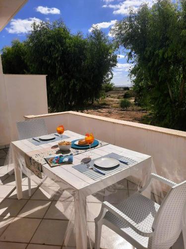 a white table and two chairs on a patio at Fronte Mare in Torre San Giovanni Ugento