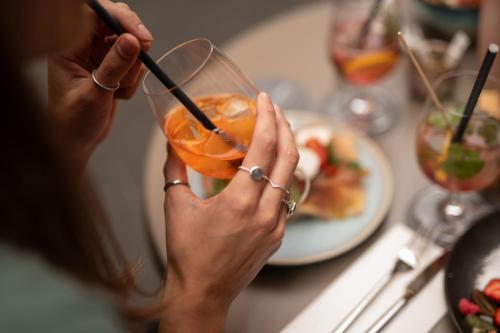 a woman sitting at a table with a drink at Kuntino Suites in Merano