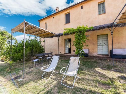 a patio with chairs and a table in front of a house at Comfortable apartment with stunning views, near hot springs in Celle sul Rigo
