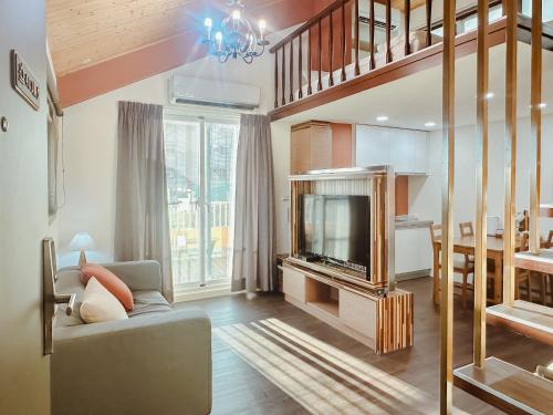 a living room with a couch and a tv at 運河十六 海港景觀整層主臥房Canal16 HarborView Studio in Tainan