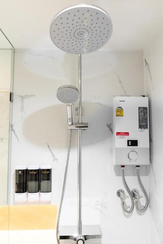 a shower in a bathroom with a mirror at indigo Hotel Hatyai in Ban Kohong