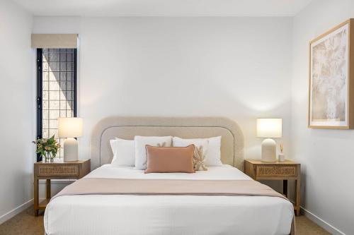 una camera da letto con un letto grande con due comodini di Bokarina 3-Bed Stunning Home, Steps from Beach a Kawana Waters