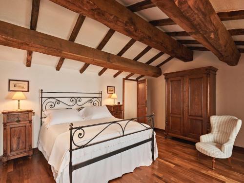 a bedroom with a bed and a chair at Charming House in Umbria with Pool and Garden in Monte Castelli