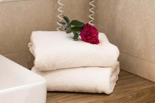 a rose sitting on top of towels in a bathroom at Fontane Hotel in Schorfheide
