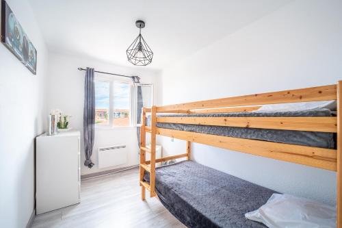 une chambre avec un lit superposé et un miroir dans l'établissement La Bastide 1 - Appt avec piscine Barcarès, au Barcarès