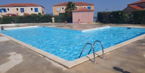 une grande piscine bleue dans une cour dans l'établissement La Bastide 1 - Appt avec piscine Barcarès, au Barcarès