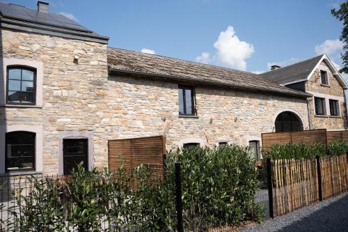a stone house with a fence in front of it at Kom à 6 in Vielsalm