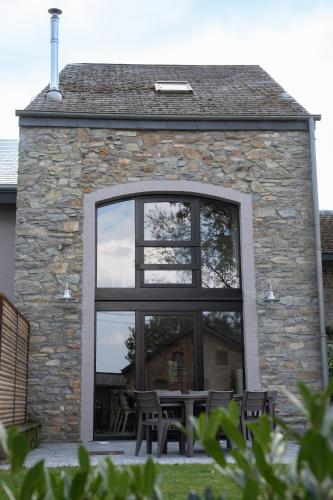 a building with a large window with a table and chairs at Kom à 6 in Vielsalm