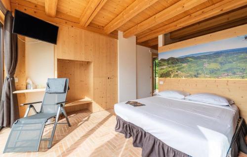 a bedroom with a bed and a chair in it at Chalet Dolce Colle in Volpago del Montello