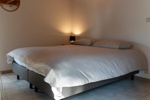 a bedroom with a large bed with a lamp on it at Kom à 6 in Vielsalm