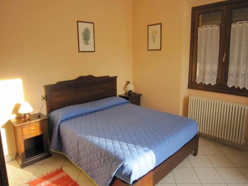 a bedroom with a bed with a blue comforter at Farmhouse in Verbania with Lake Views in Verbania