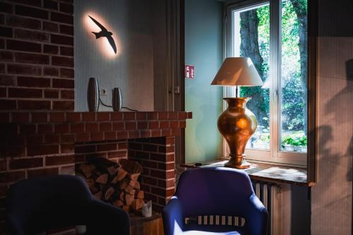 a living room with two chairs and a lamp next to a fireplace at Seehotel Frankenhorst - BW Signature Collection in Schwerin