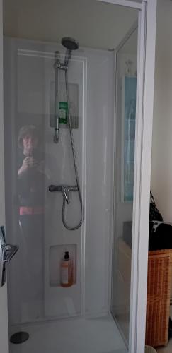 a shower with a glass door in a bathroom at Le jardin pictural de Garance in Chédigny