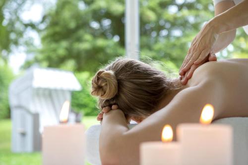 a woman getting a massage from a therapist at Strandhafer Aparthotel in Warnemünde