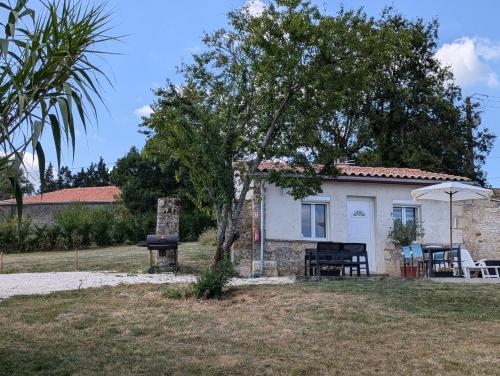 une petite maison blanche avec une table et un arbre dans l'établissement Petit gîte de charme Bichta Eder, à Magnac-Lavalette
