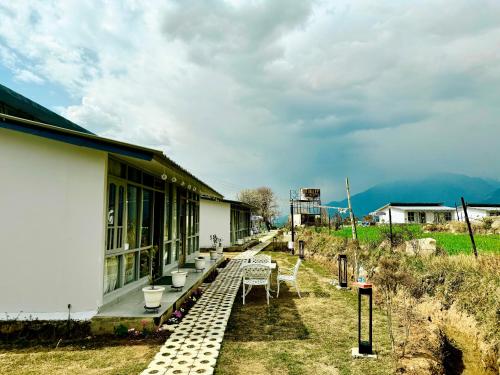 a building with a table and chairs outside of it at Bir Valley Retreat in Bīr