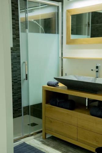 une salle de bain avec une douche en verre et un lavabo dans l'établissement Le petit paradis, à Orange